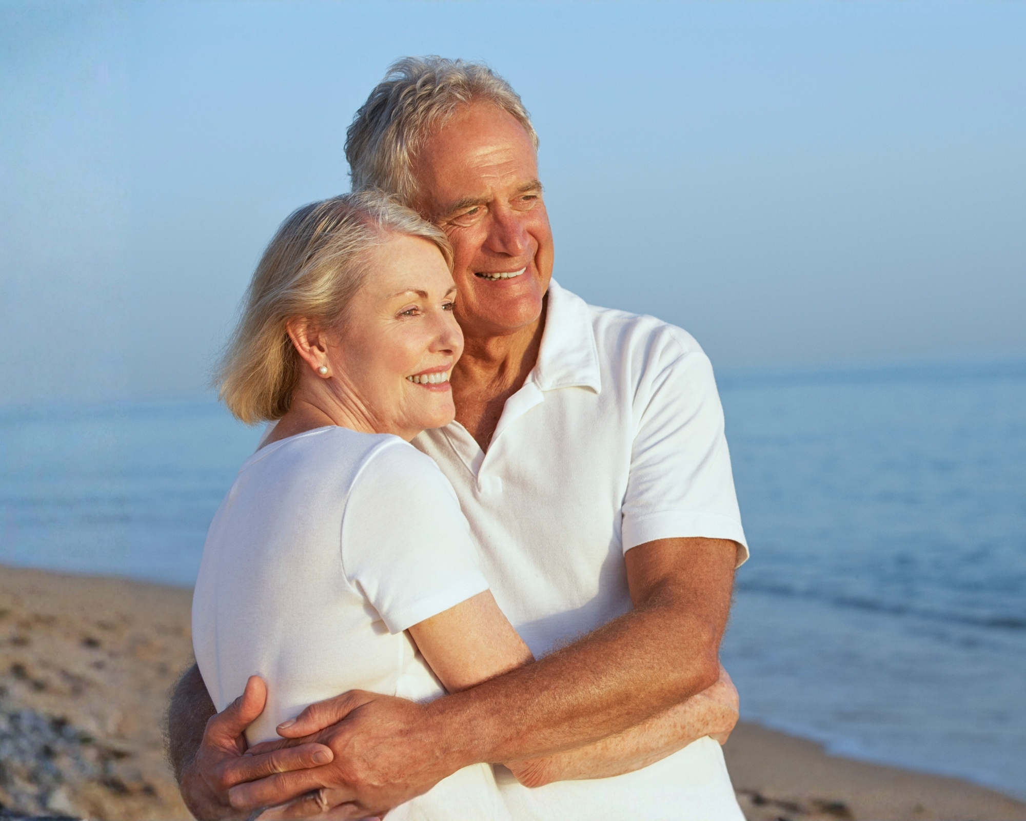 Retired Caucasian couple standing together on the Spanish coast, enjoying the seaside setting. Retired Caucasian couple standing together on the Spanish coast, enjoying the seaside setting.