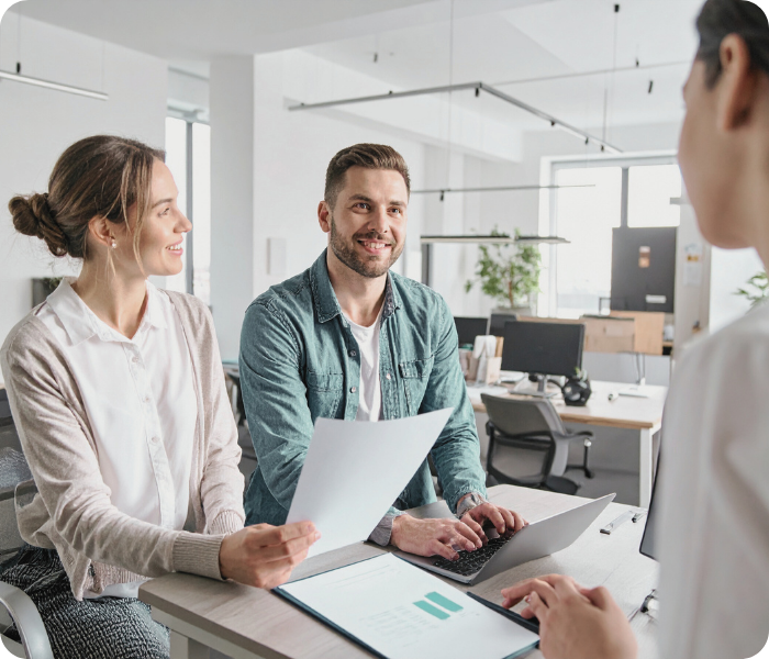 Couple smiling while filing their Modelo 210 tax form with a trusted advisor