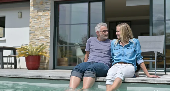 Older couple relaxing by a private pool in Spain after managing taxes with Iberian Tax